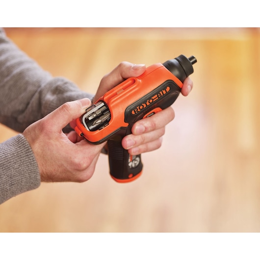 Photo of BLACK+DECKER CS36BST cordless screwdriver with integrated bit storage, shown held in hand indoors.
