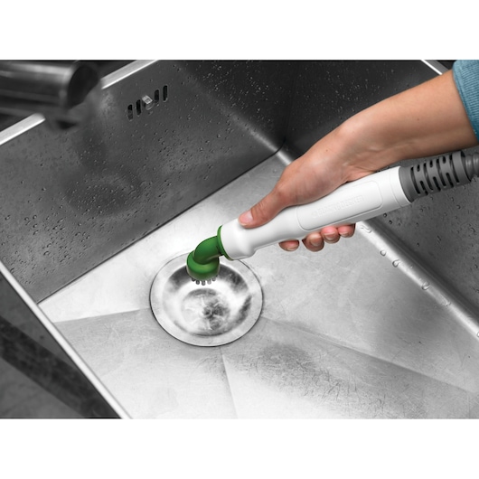 BLACKDECKER FSMH1321JSM steam cleaner with green brush attachment cleaning a stainless steel sink.