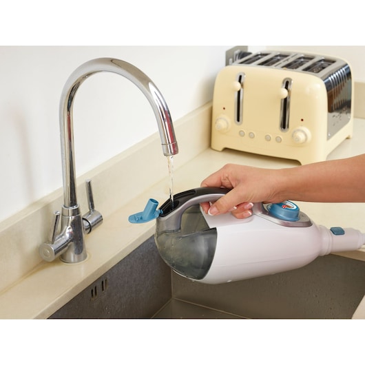 BLACKDECKER FSMH1321JSM steam mop water tank being filled at kitchen tap, close-up photo.