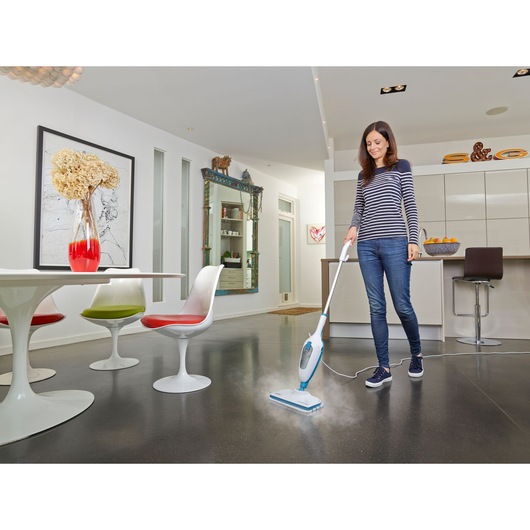 BLACK+DECKER FSMH13ENVC1 steam mop cleaning kitchen floor, woman using product in modern home setting.