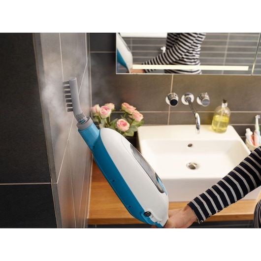BLACKDECKER FSMH13ENVC1 steam cleaner in blue and white used on bathroom wall tiles near sink.