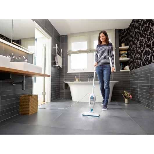BLACKDECKER FSMH13ENVC1 steam mop cleaning bathroom tile floor, person holding handle, wide angle.