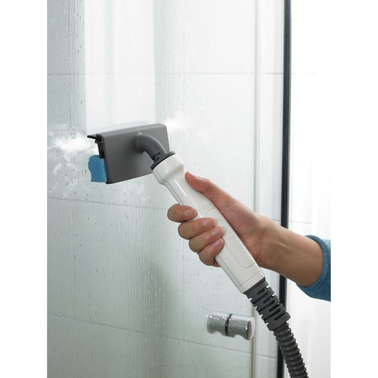 Photo of BLACKDECKER FSMHBA steam cleaner handheld attachment cleaning glass shower door.
