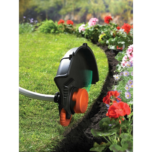 BLACKDECKER GL8033 garden trimmer edging lawn next to flower bed outdoors.