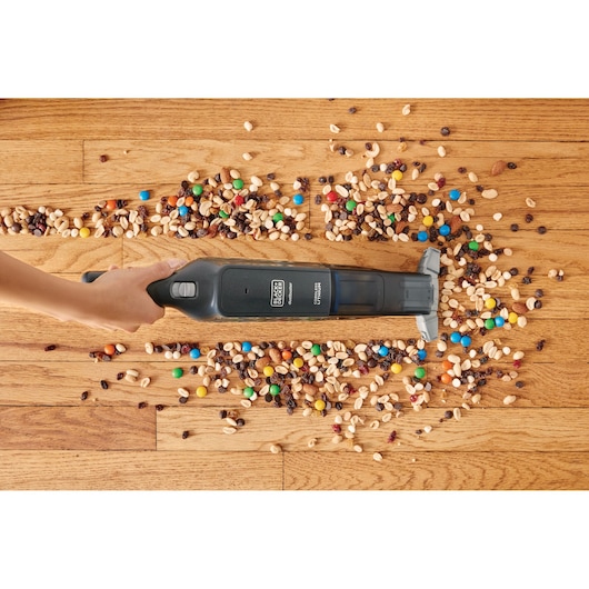 BLACK+DECKER HLVC320B11 handheld vacuum cleaning colorful snacks on hardwood floor, top view