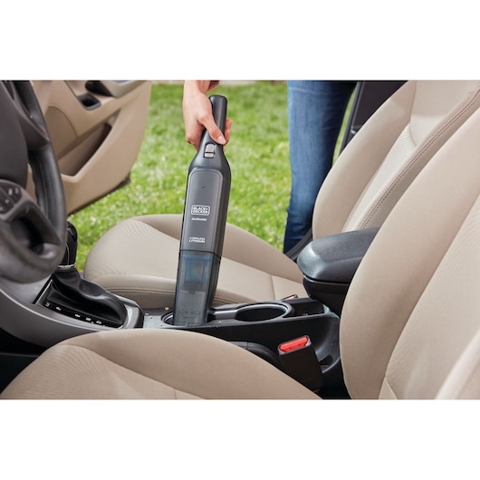 BLACKDECKER HLVC320J11 handheld vacuum used to clean car seats and console, photography.