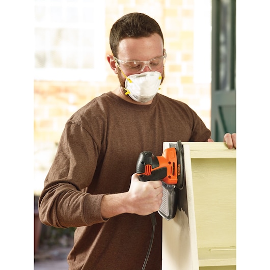 BLACKDECKER KA2000 mouse sander in use on wood shelf, photography of product held by person.
