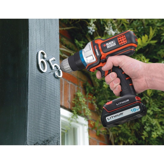 BLACKDECKER MT18K cordless drill being used to install house numbers outdoors.