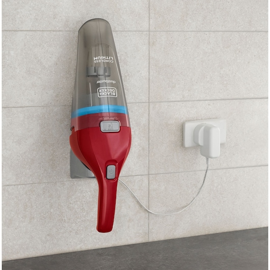 BLACK+DECKER handheld vacuum NVC115WAR in red and grey, wall-mounted and charging on a tiled wall.