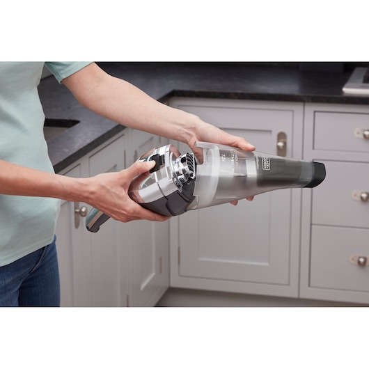 Photo of BLACK+DECKER NVC220WC handheld vacuum cleaner in kitchen setting.