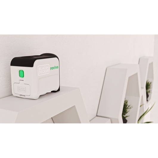 BLACKDECKER REVBDLL100 laser level with black and white casing on a white shelf, side angle.