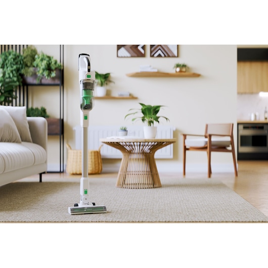 BLACKDECKER REVSV18D1 cordless stick vacuum cleaner standing on a beige carpet in a modern living room.
