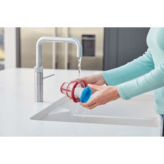 BLACKDECKER SVB520JW vacuum filter being rinsed under faucet in kitchen, close-up photography.