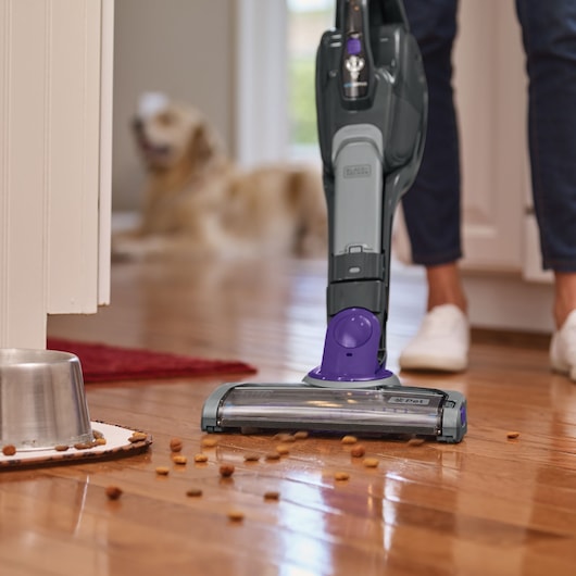 BLACKDECKER SVJ520BFSP pet vacuum cleaning scattered pet food on hardwood floor, close-up.