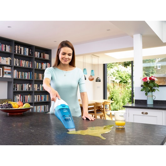 Photo of BLACKDECKER WDC115WA handheld vacuum cleaning juice spill on kitchen counter.